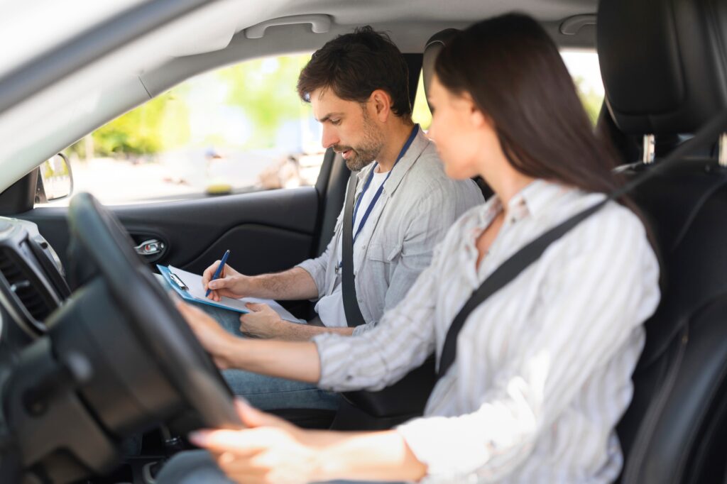 Handsome young man instructor examining woman driver