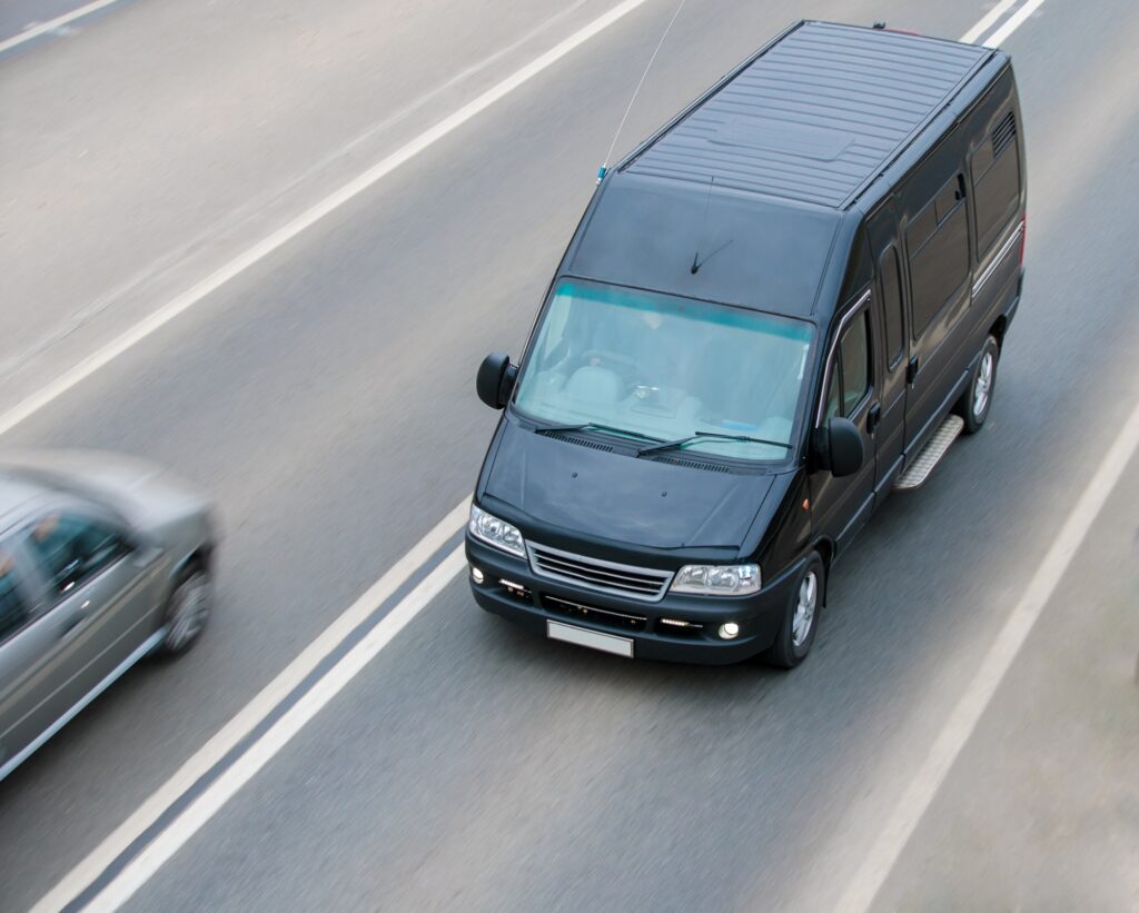 The black minibus goes on a suburban highway