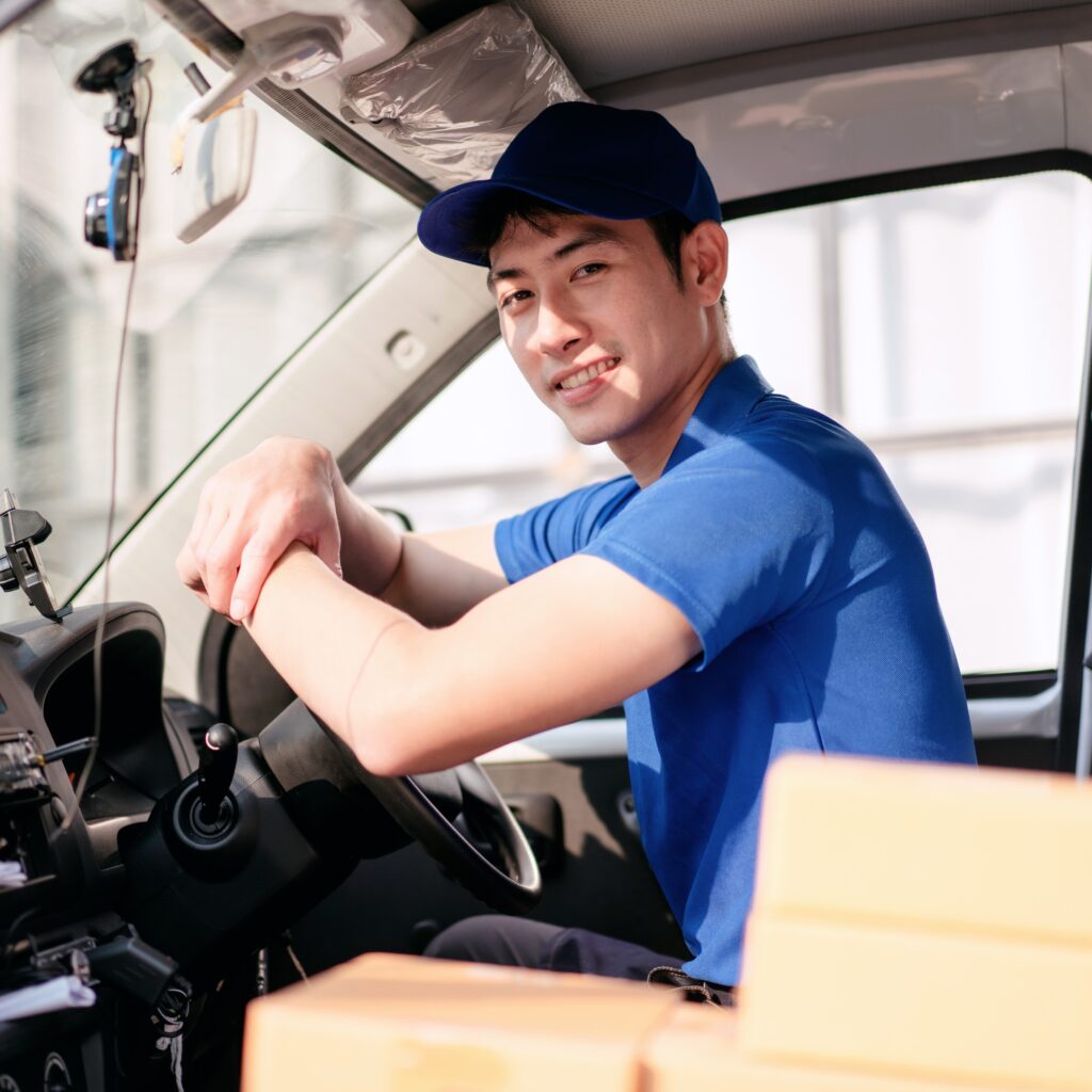 A man in a blue shirt is driving a truck
