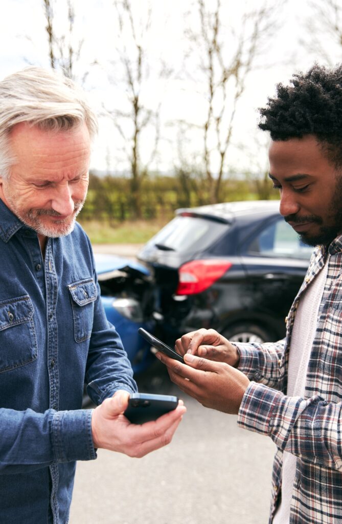 Senior Male Driver Exchanges Car Insurance Details With Younger Motorist After Road Traffic Accident
